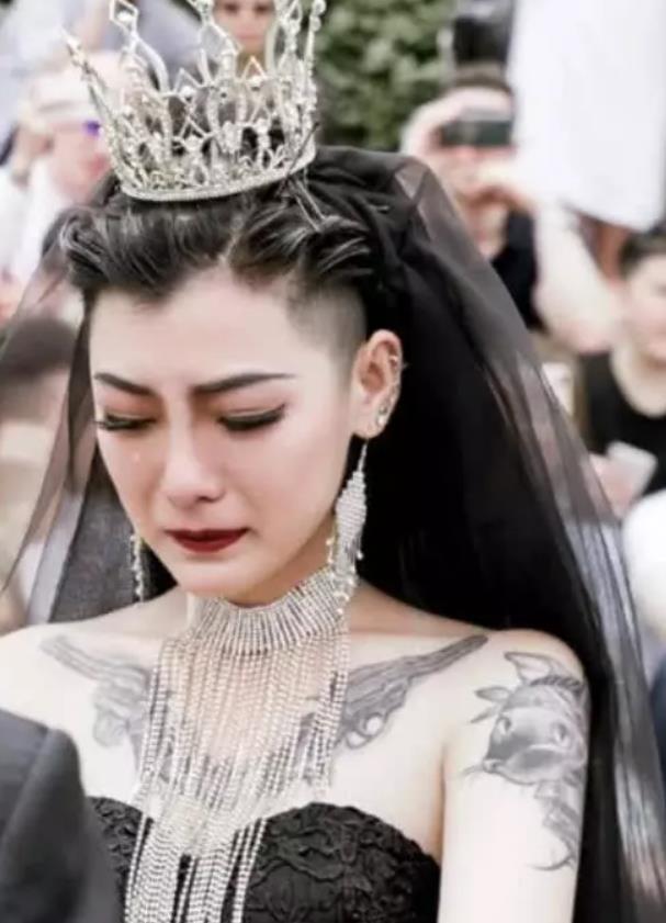 因为和真爱结婚时穿了一件黑色婚纱而走红,图中她带着皇冠纹着纹身,看