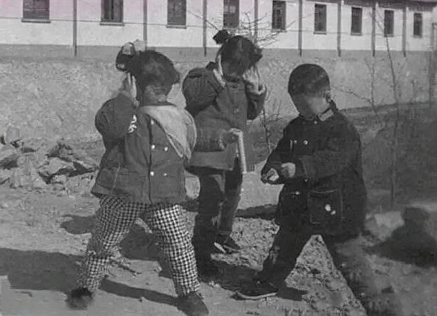 80年代旧照,照片中的两个小女孩胆小怕事,不敢玩鞭炮他们竖起耳朵