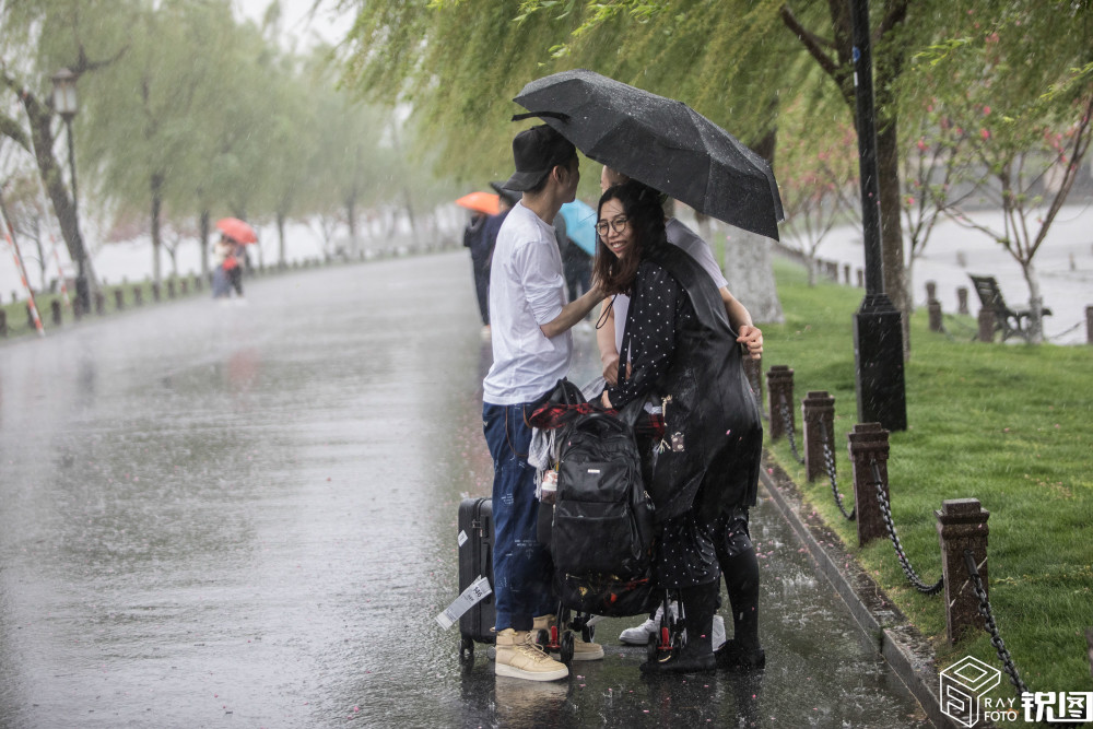 杭州突降暴雨,西湖边女游客抱成一团防淋湿,网友:画面