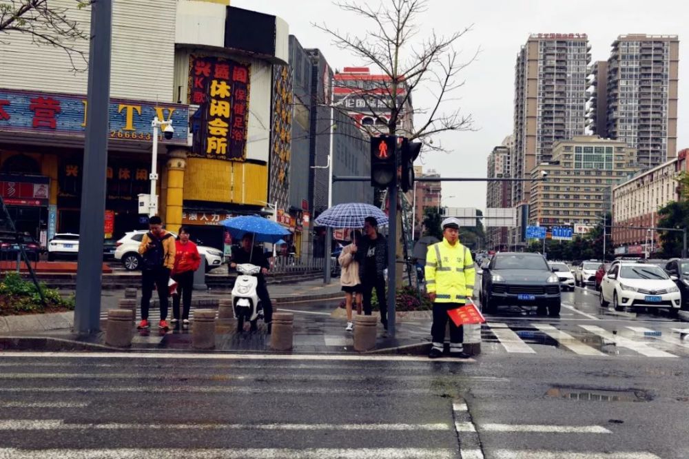 下雨天,这群龙华街道人为什么一直站在雨里?