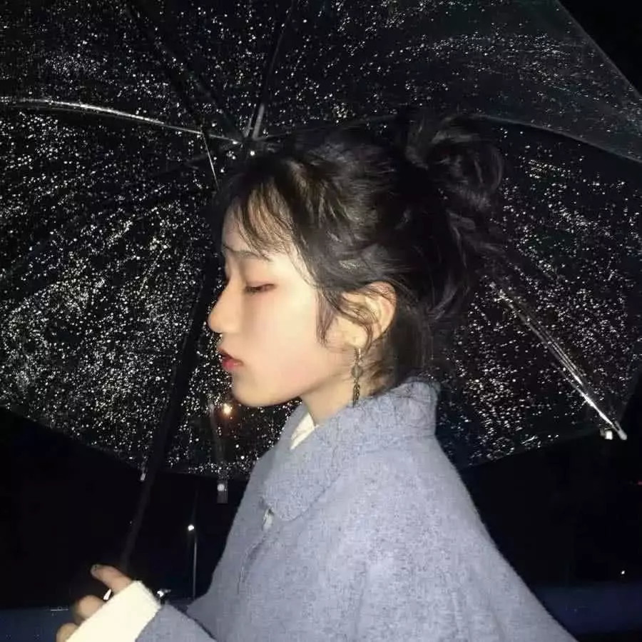 2,黑色的背景下一个穿着灰色的衣服的女孩子撑着一把黑色的雨伞,给人