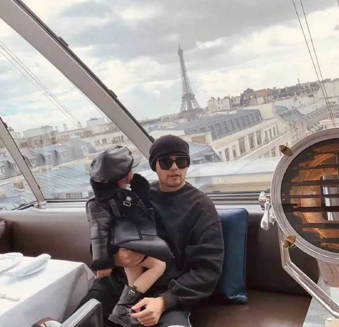 周杰伦晒女儿背影照,小周周扎小辫抱宠物狗,一脸认真欣赏艺术