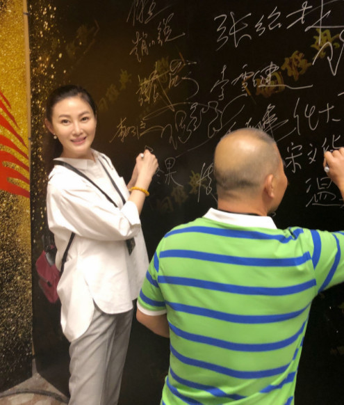 王思懿和武大郎的饰演者宋文华一同在签名墙签名合影.