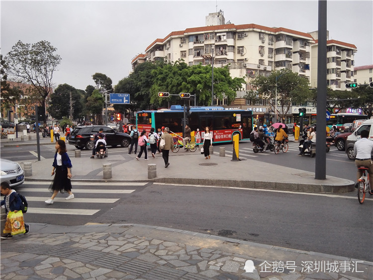 深圳龙华:下班的十字路口,有志愿者在指挥行人过马路