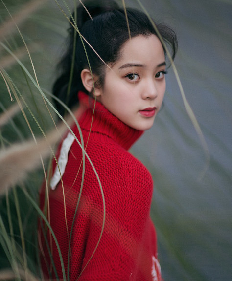身穿一件红色的毛衣,扎着高高的马尾辫,这样的形象显得欧阳娜娜十分