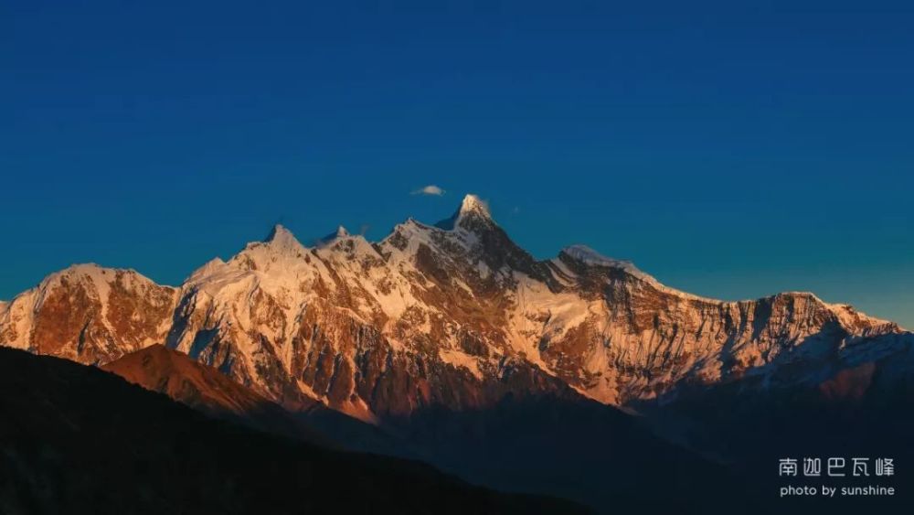 南迦巴瓦峰别称"木卓巴尔山",其巨大的三角形峰体终年积雪,云雾缭绕