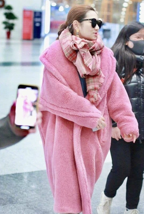 任家萱机场街拍照,身穿粉色泰迪绒大衣,满满的少女心
