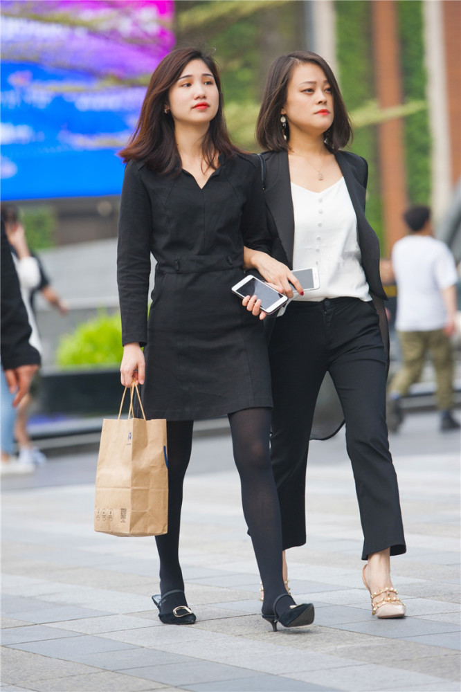 路人街拍:美女销售手挽手下班,穿着工作服,非常的敬业