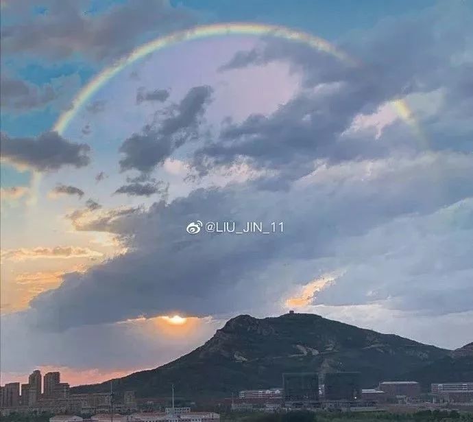雨后的景色美,天空出现了二道美丽的彩虹桥,天空中闪闪发光,云彩密布