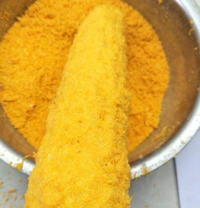 7,把玉米均匀的裹上一层的面包糠,面包糖.