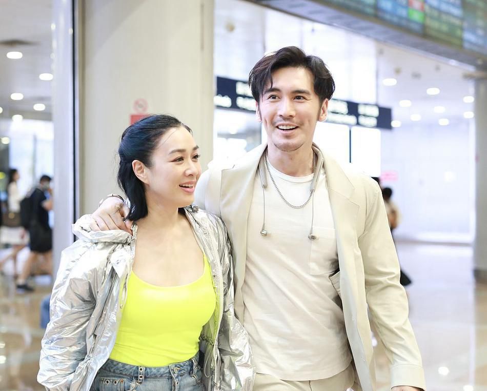 钟丽缇牵手丈夫走机场,再穿荧光色打底衫,这回搭破洞短裤更潮范