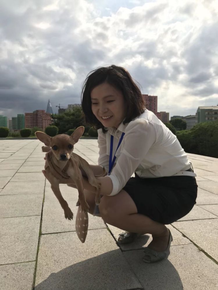 图为一名抱着宠物的朝鲜女导游,这名女导游非常可爱.