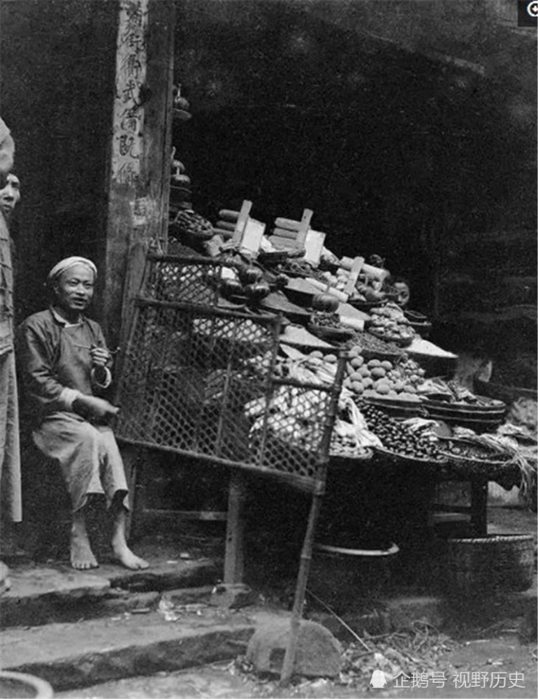 图为1917年,四川遂宁县的水果摊,摊主没有穿鞋,手里拿着旱烟锅,这个