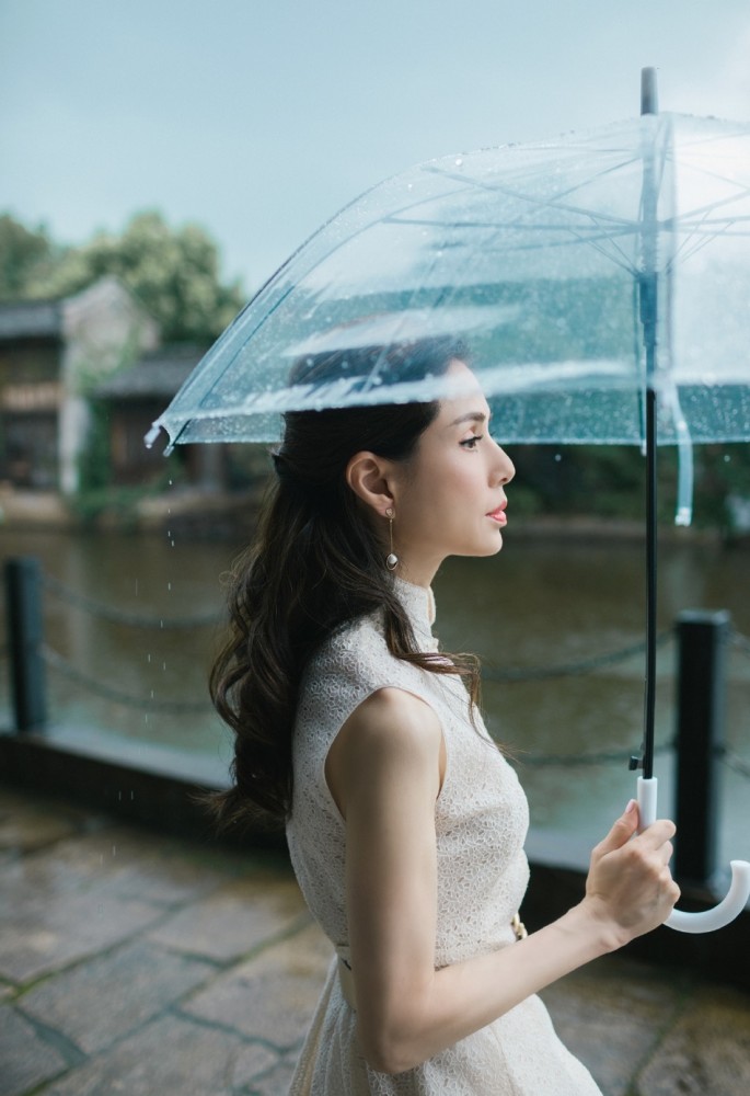 气质女神李若彤撑伞雨中漫步古镇,犹如仙女降落凡尘般