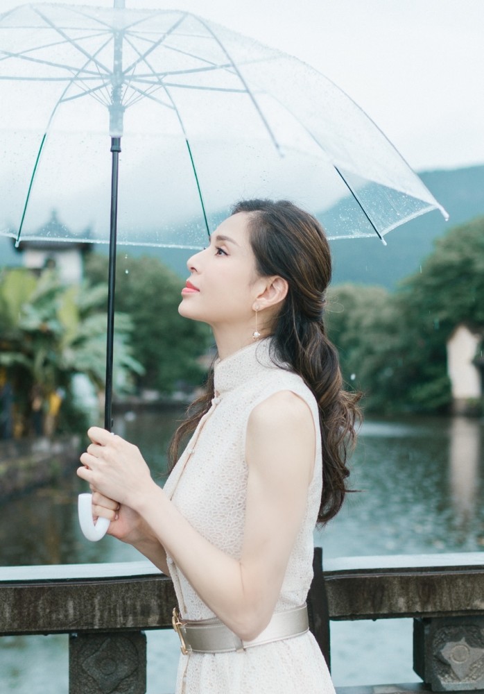 气质女神李若彤撑伞雨中漫步古镇,犹如仙女降落凡尘般