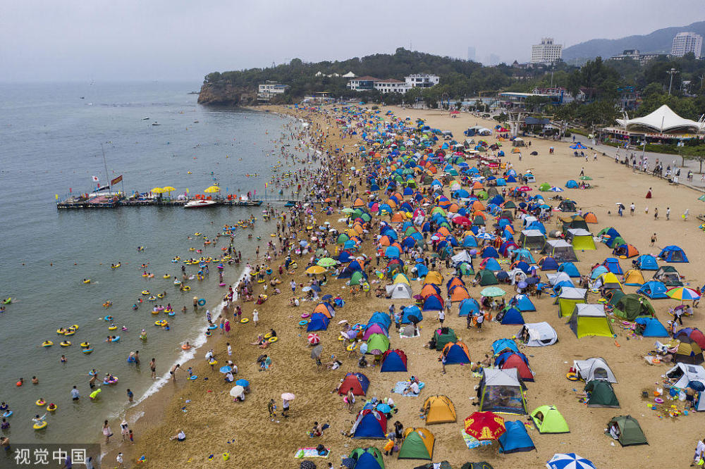 大连暑夏正热,海滨浴场只见人头不见沙滩