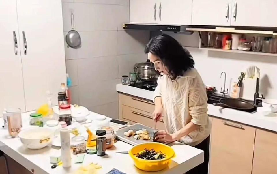 50岁知名歌手复出后仍显坎坷，边唱歌边做饭，厨房狭小手法很娴熟_腾讯新闻