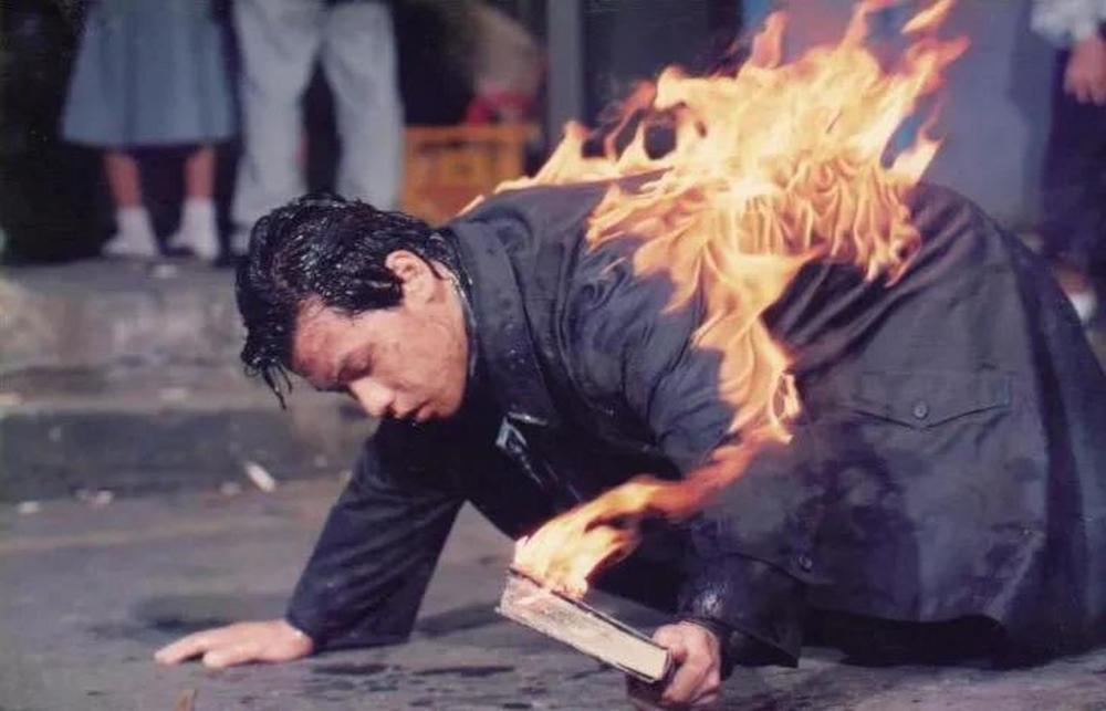 惊恐的人群看到,火焰中的全泰壹,竭尽全力,举着一