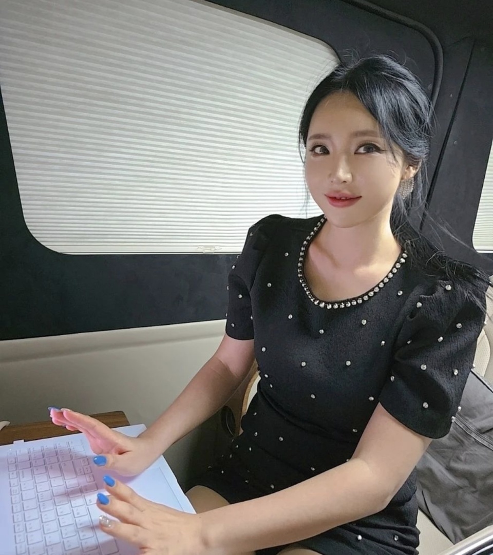 洪真英车内忙工作,头发散乱仍微笑