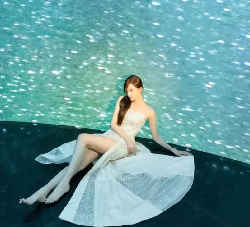 风格一:一袭白色长裙,林志玲斜靠着,裙子分叉到大腿处,将她的大长腿