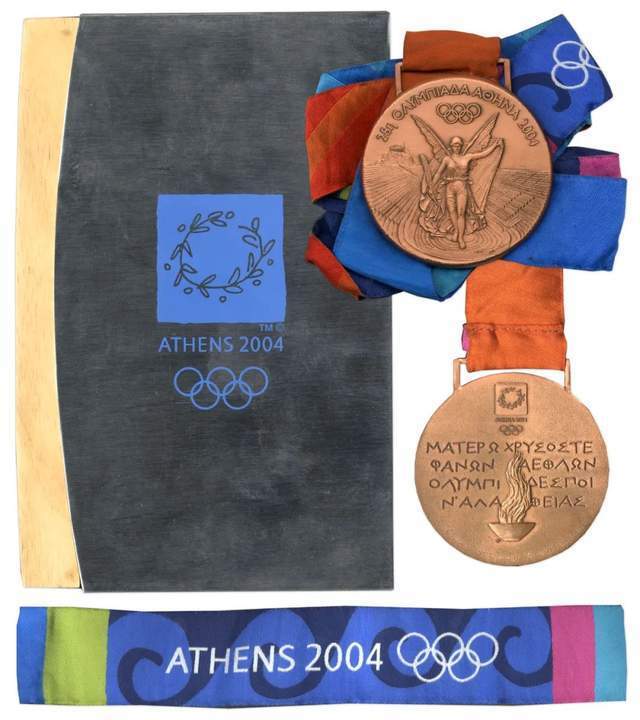 2004年希腊雅典奥运会奖牌的背面是在奥林匹亚点燃的圣火,以及诗人