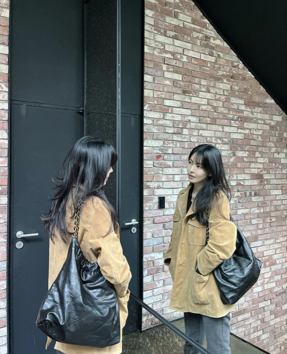 照片中的金素妍身穿米色宽松款羊羔皮衬衫和灰色牛仔裤,展示出一种