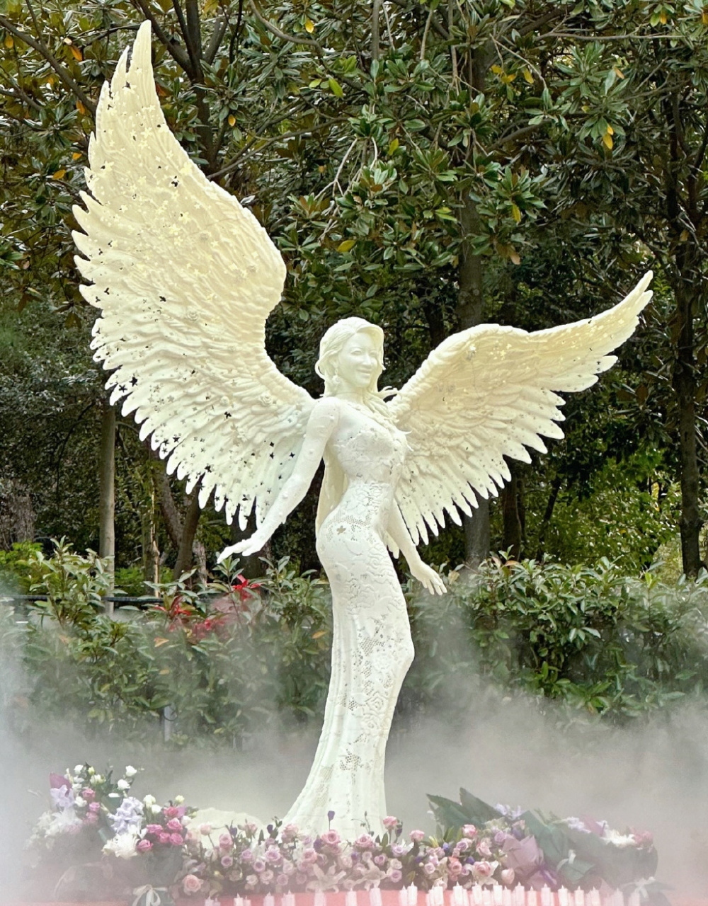 在墓地旁,伫立着汉白玉天使造像,纪念展横幅写着武汉姑娘回家,公园