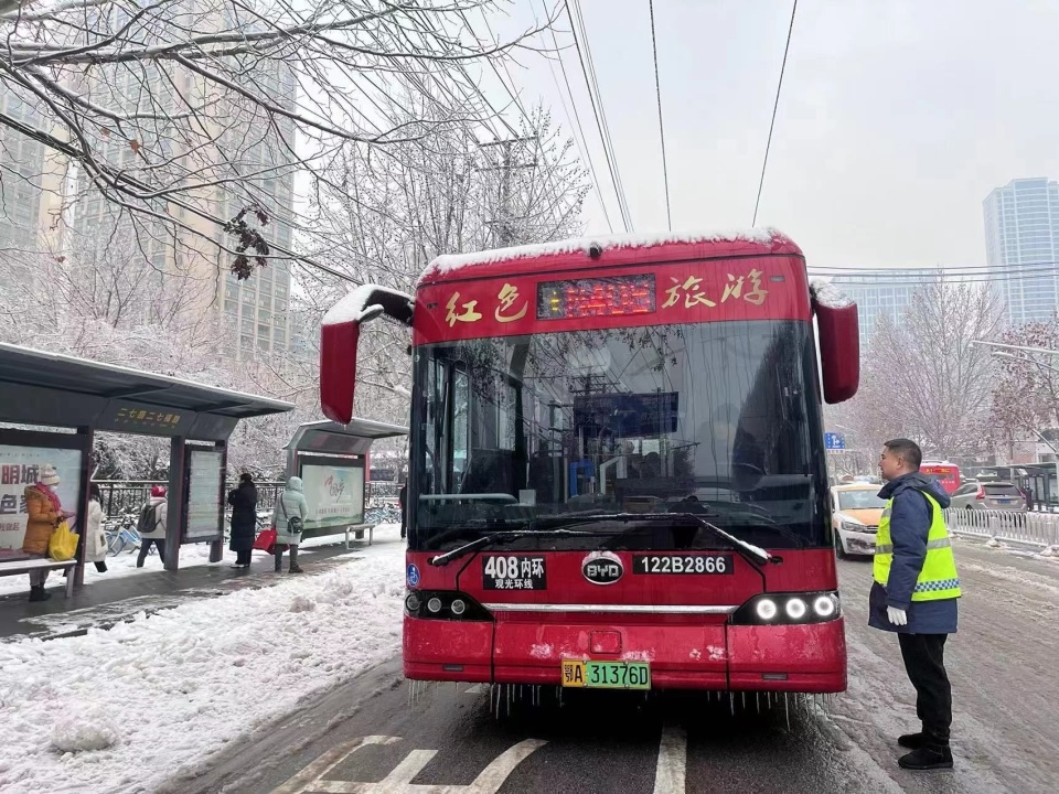 來暖暖身子公交人給候車乘客送上熱水