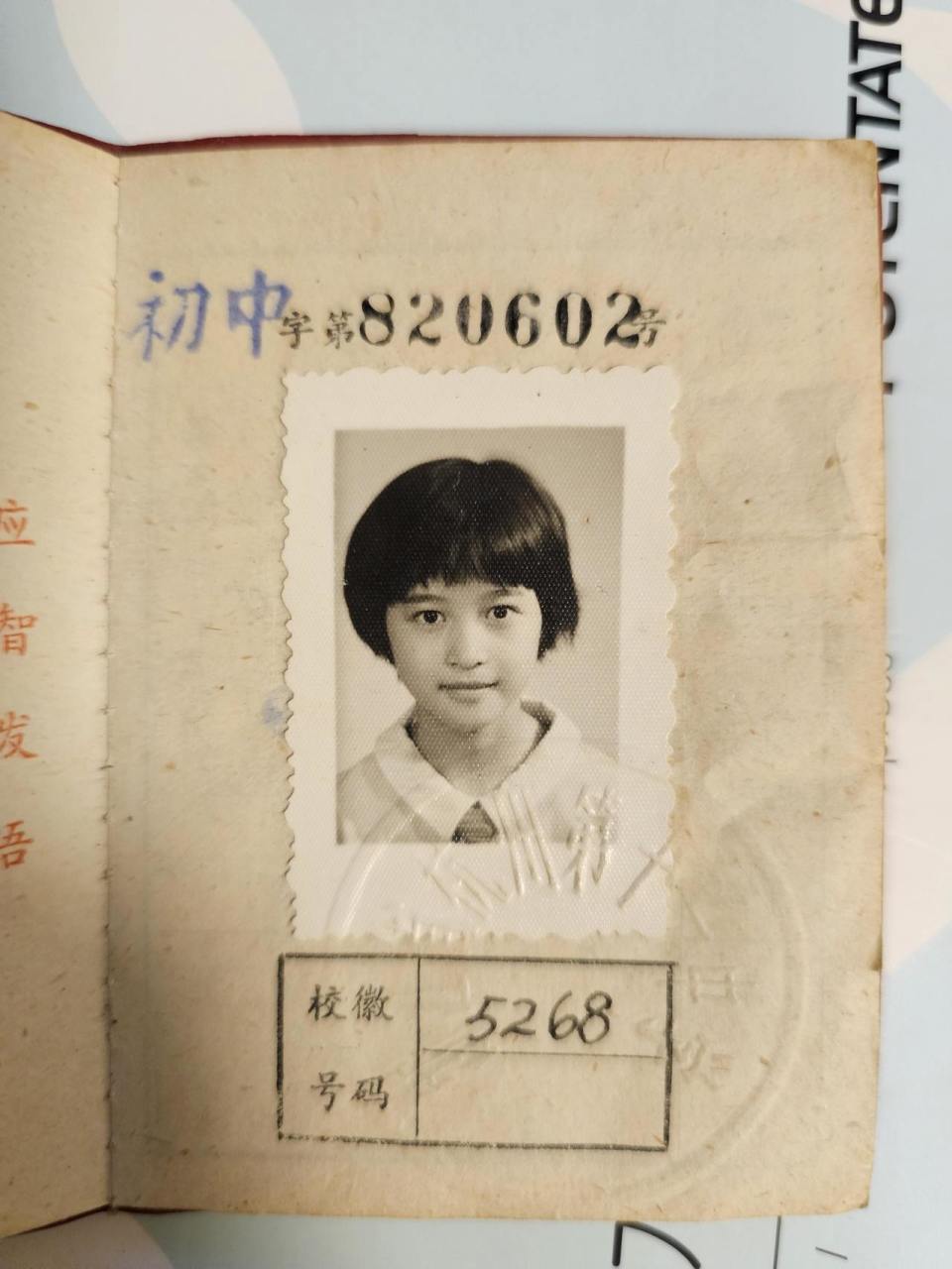 翻开学生证,第一页是一张黑白照片,小女孩留着齐肩短发,一旁还夹有