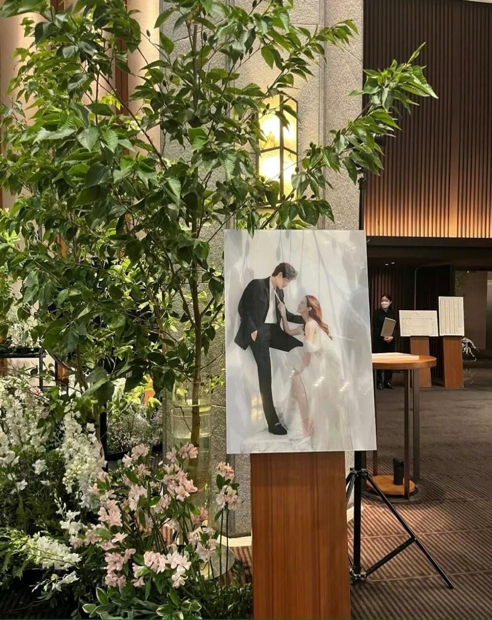 在绿植花丛处,李多海与老公崔东旭的结婚照被摆放其中,小两口亲腻的