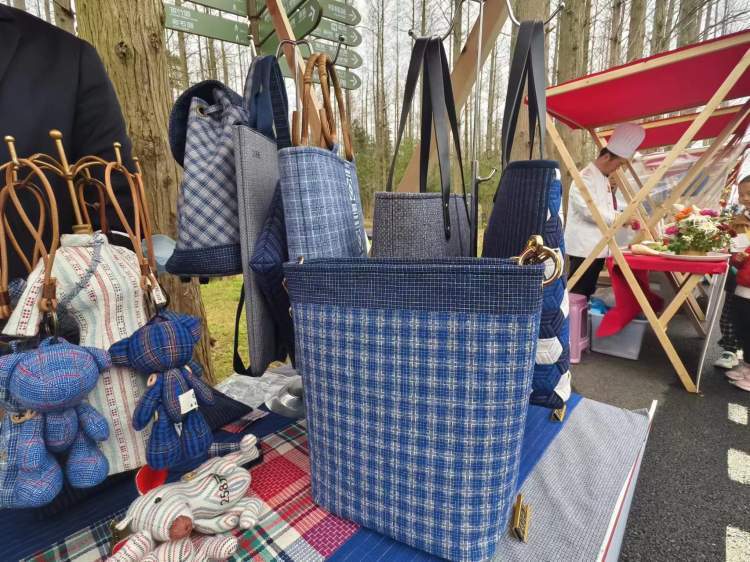 摊位工作人员介绍说,这是他们最受欢迎的崇明土布包包之一,采用芦纹和