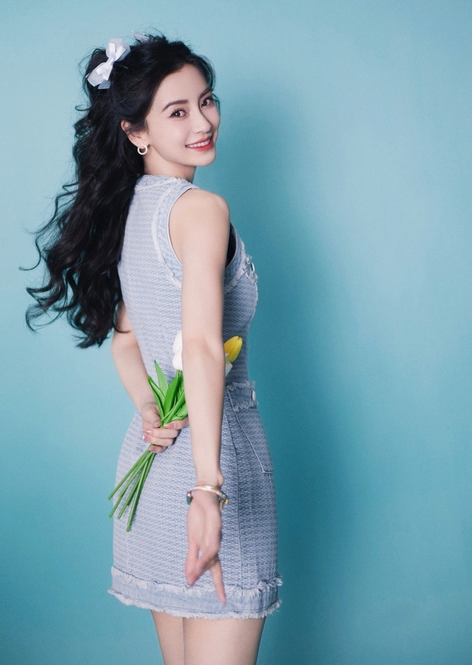 杨颖拿着鲜花单手背在背后摆pose,她侧身上演"回眸杀",笑起来的样子