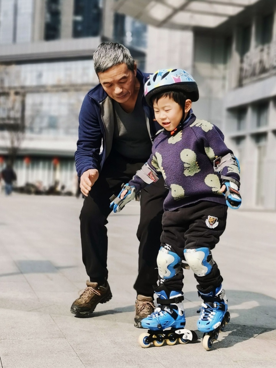 在爷爷的鼓励下,小孙子终于一点点试着向前滑了起来,伴随而来
