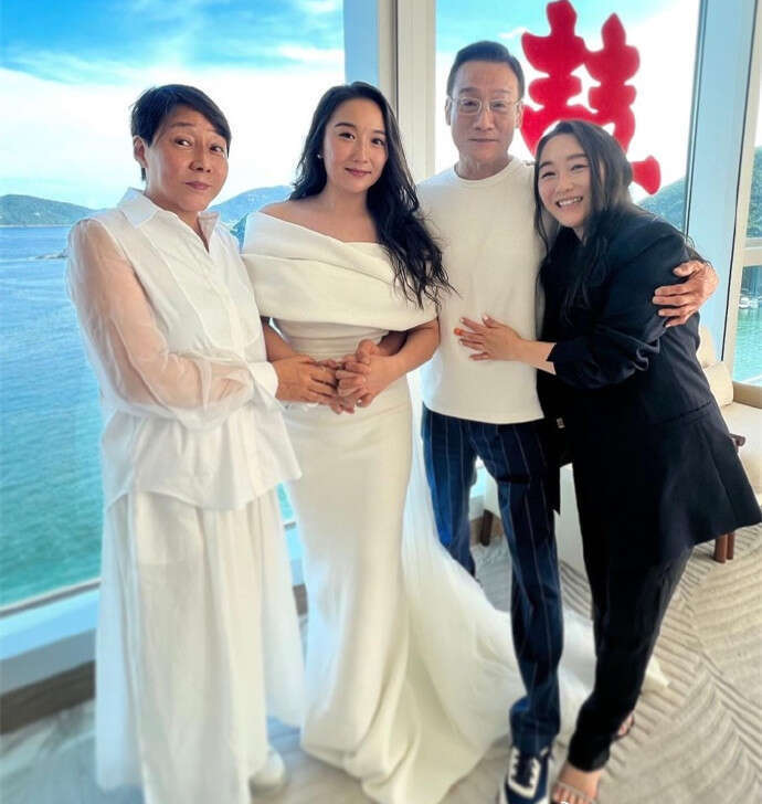 穿白色套装,剪了一头短发的女士,便是梁家辉的妻子江嘉年.