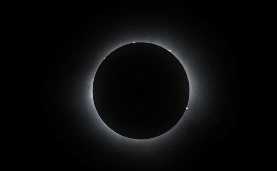 月亮看起来像一个黑色的球体在太阳前爬行,短暂地遮蔽住太阳的光芒