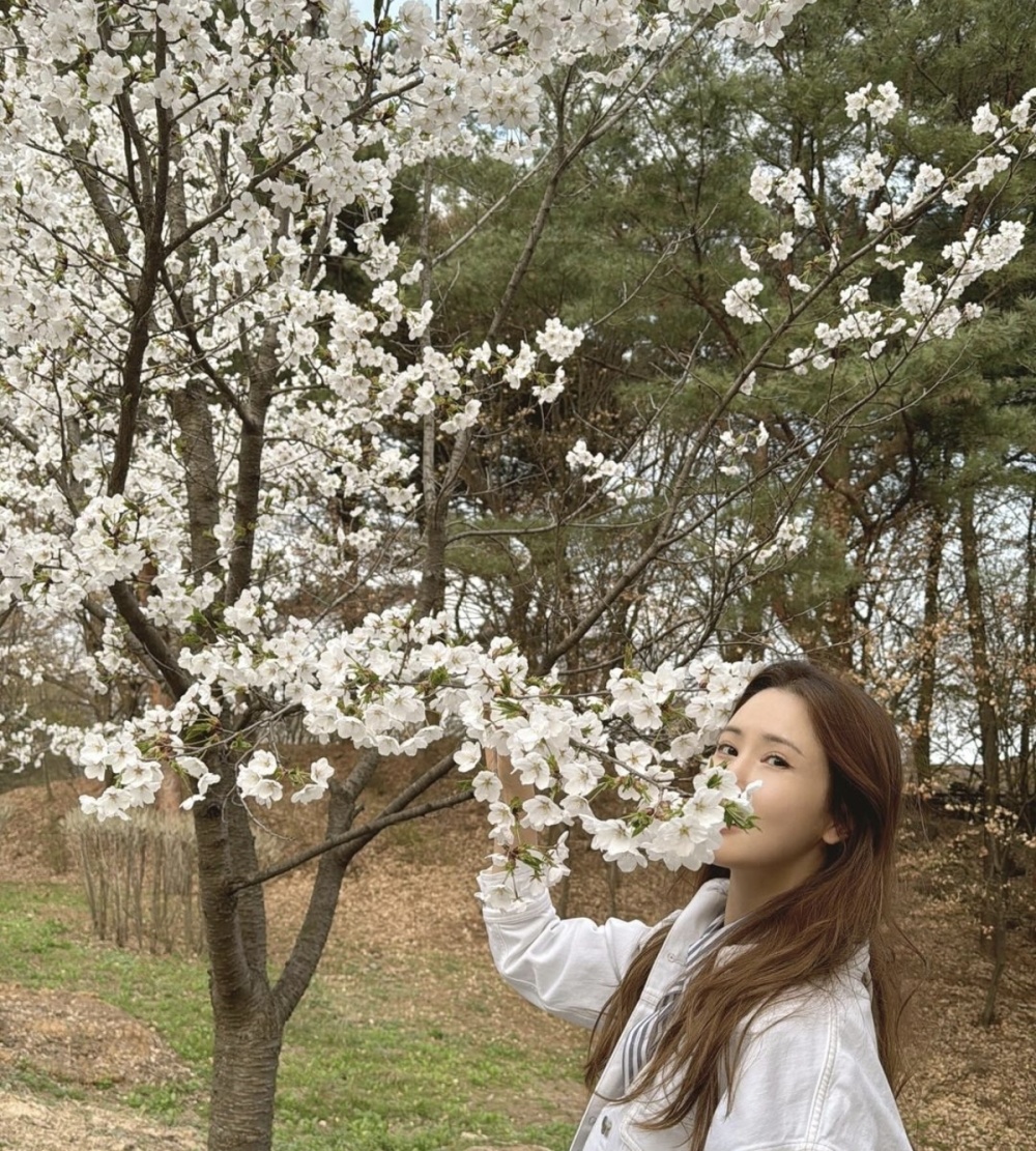 站在樱花树下,李多海长发自然卷曲,显得十分温柔.