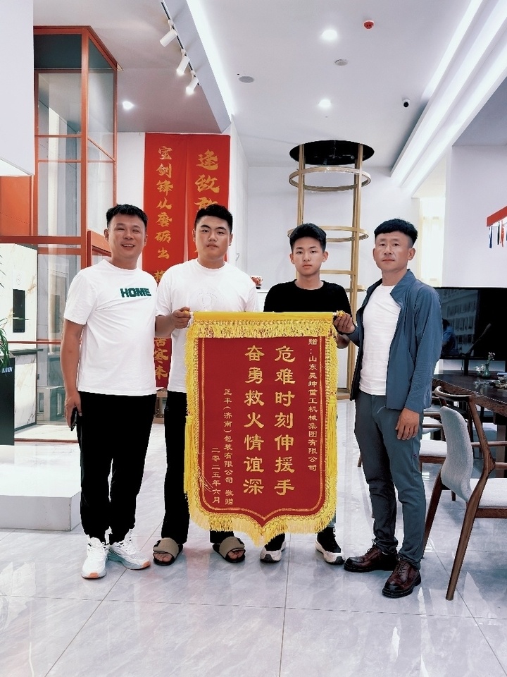 获救的货车司机捧着"危难时刻伸援手 奋勇救火情谊深"的锦旗来到张