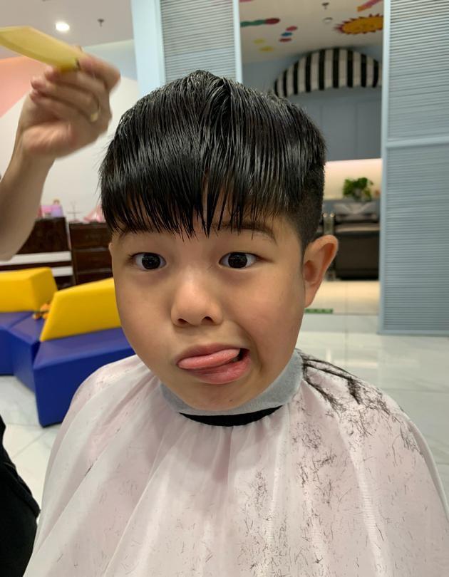 照片中的安吉,任由理发师摆弄自己的头发,表情却不闲住,对着镜头扮起