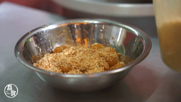 阿姨先把煮好的粉丸装碟,撒上花生粉,最后再加上鸡蛋丝.