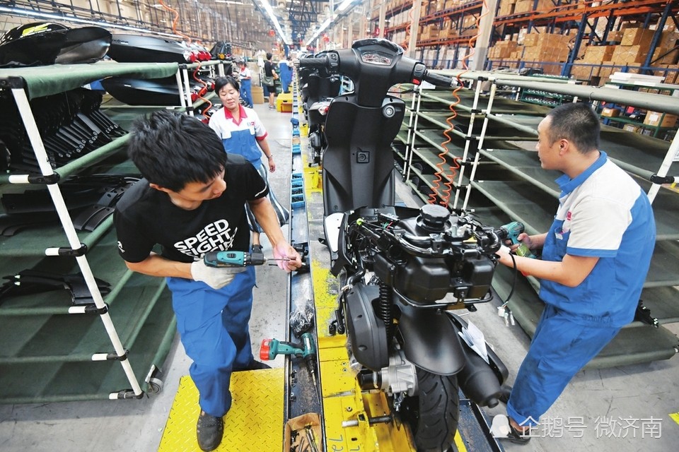 在轻骑标致摩托车有限公司,工作人员在生产车间组装摩托车.