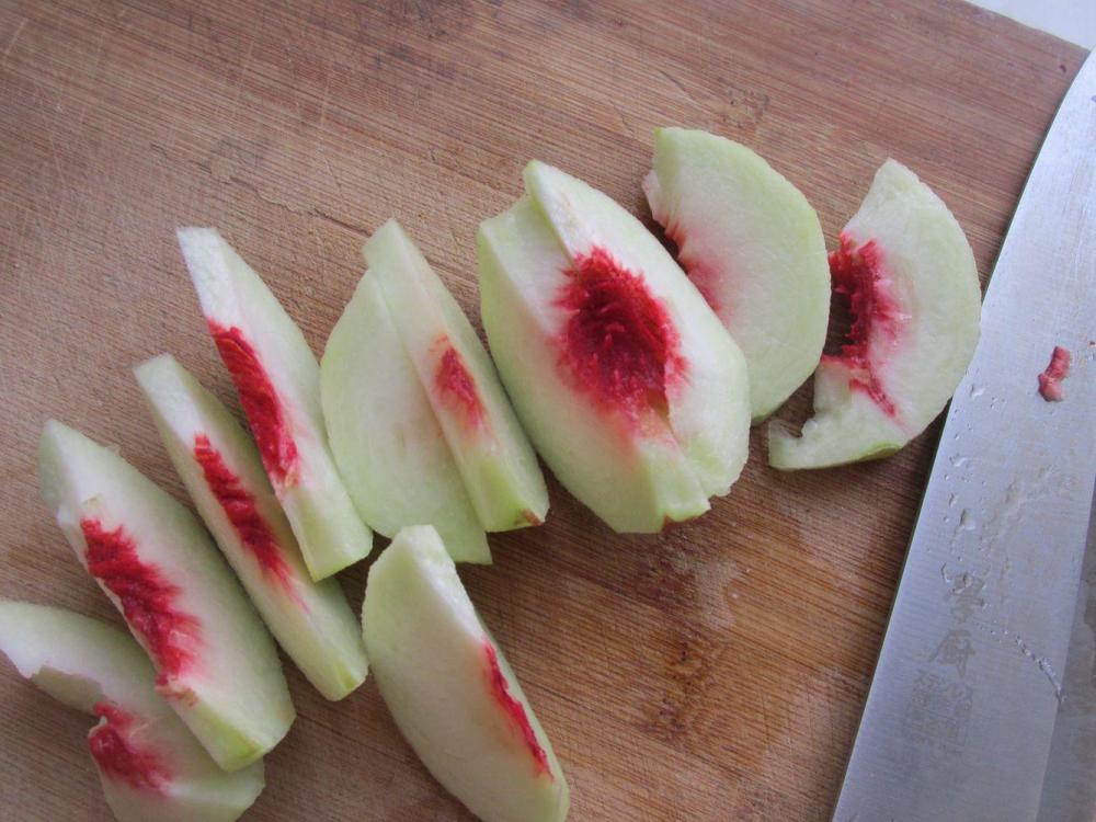 2,把桃子削去外皮,一掰两半,用刀切成小块.