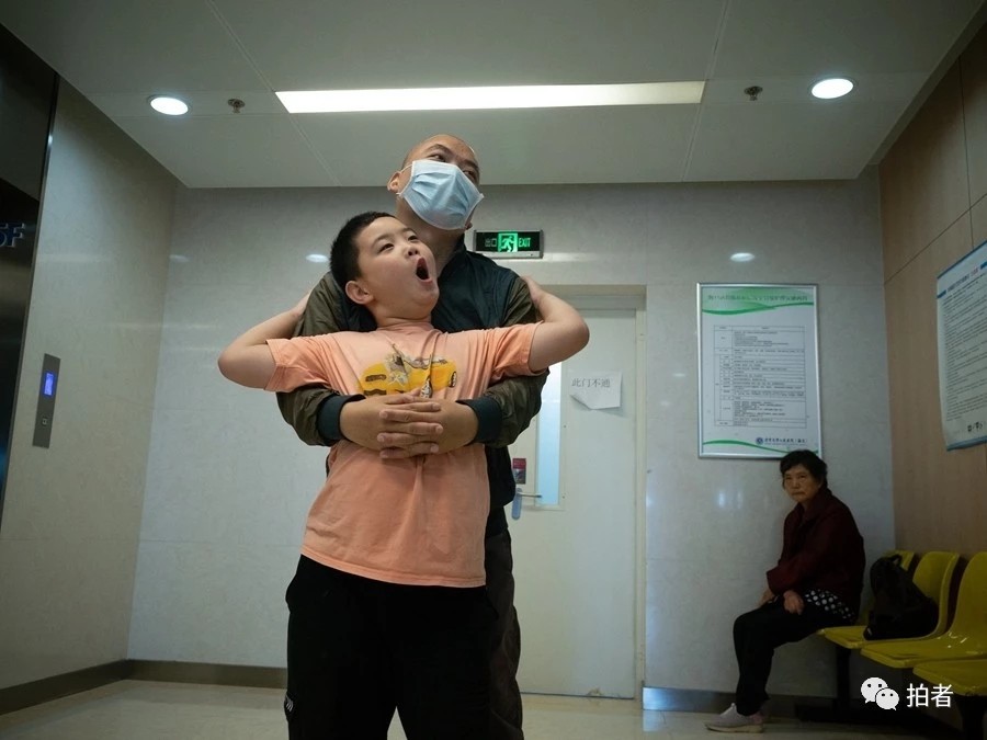 8月30日,圆明园旁人行道,路子宽蹲下身,帮爸爸挠他脚背上的蚊子包.