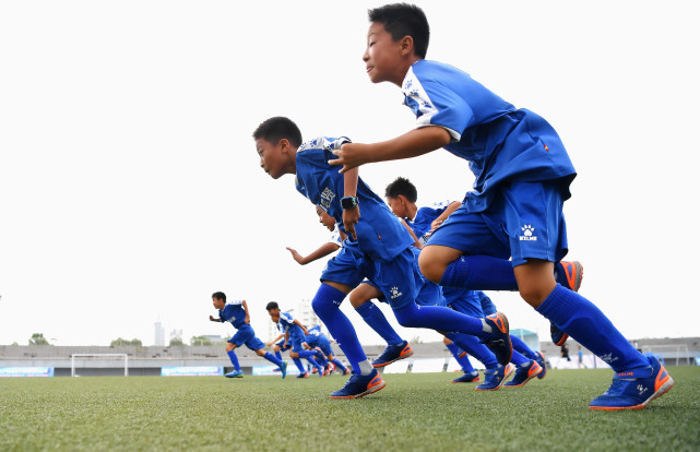 唐山海港经济开发区的城区小学的小球员们在进行体能训练.