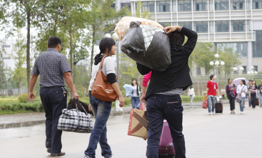 学校要开学了父母背着沉重的包送孩子上学背起的还是满满的爱