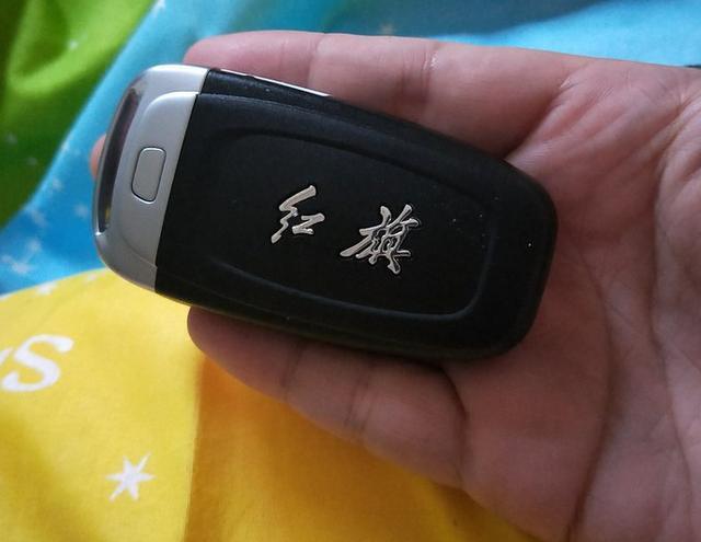 车主握着红旗h5的车钥匙显得很开心,红旗的车钥匙有种奥迪的车钥匙