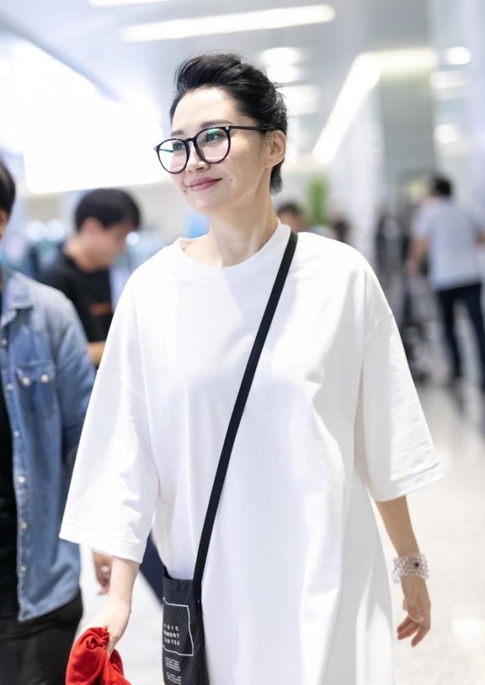 50岁女星许晴现身机场,穿白色t恤裙配玫红色运动鞋,活泼休闲