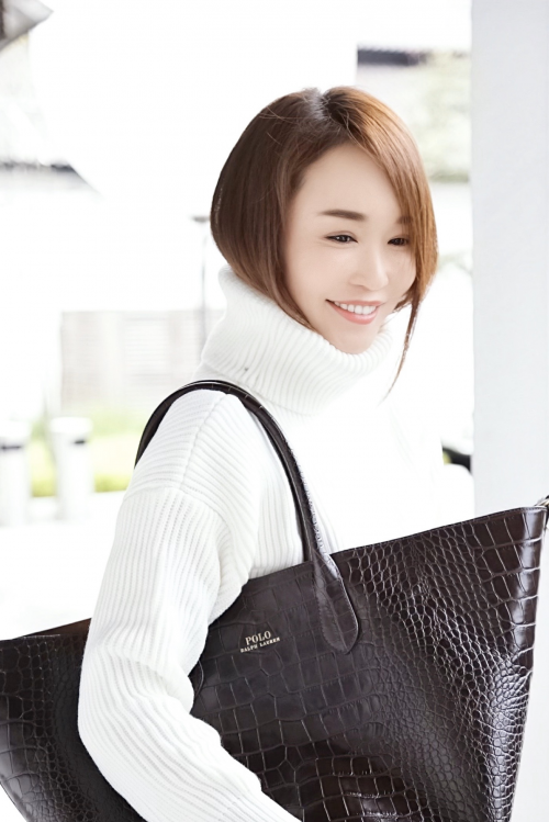 照片中范文芳身着白色高领毛衣,肩挎超大时尚饺子包,利索且性感的短发