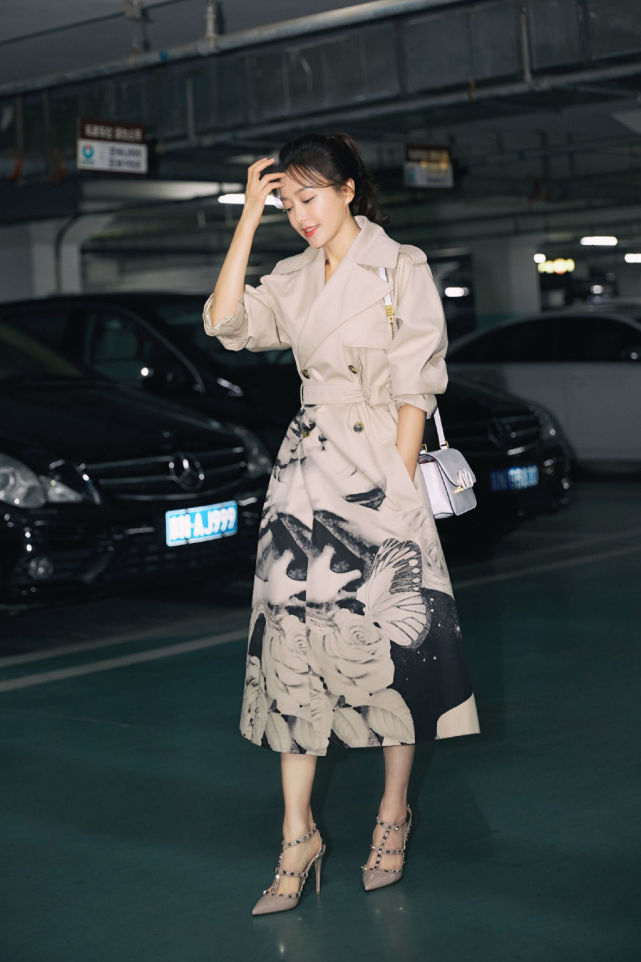 画上精致淡雅的妆容,身着一件长款驼色风衣,搭配同色系的尖头高跟鞋