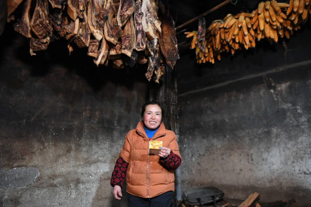 湖南龙山县翻身村村民李红云在展示自家的储蓄卡（3月10日摄）。新华社记者 薛宇舸 摄