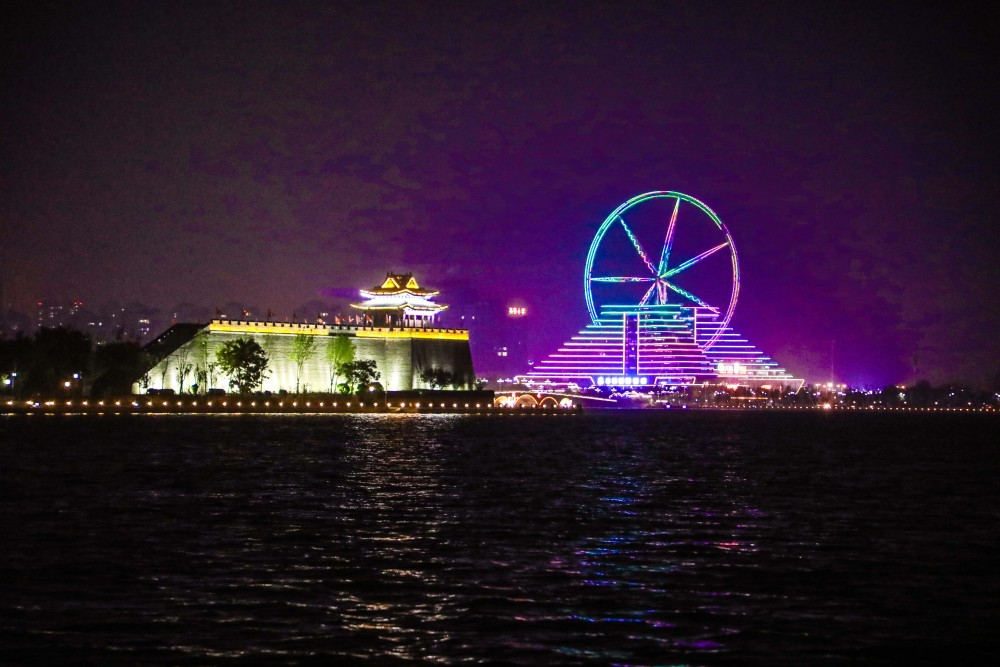 游客欣赏着美丽的东昌湖夜景,陶醉在江北水城璀璨的夜色里.